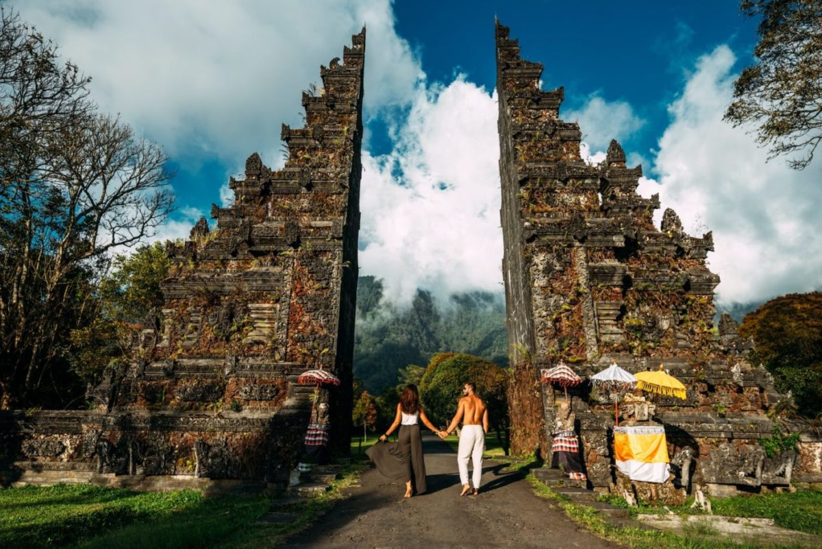 Beautiful couple at the Bali temple. Man and woman traveling in Indonesia. Couple at the Bali gate