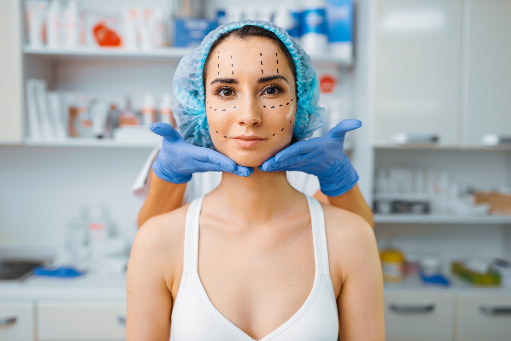 Cosmetician and patient with markers on her face