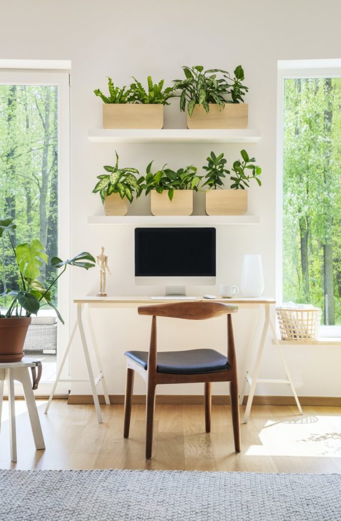 Wooden chair at desk with desktop computer in bright workspace i