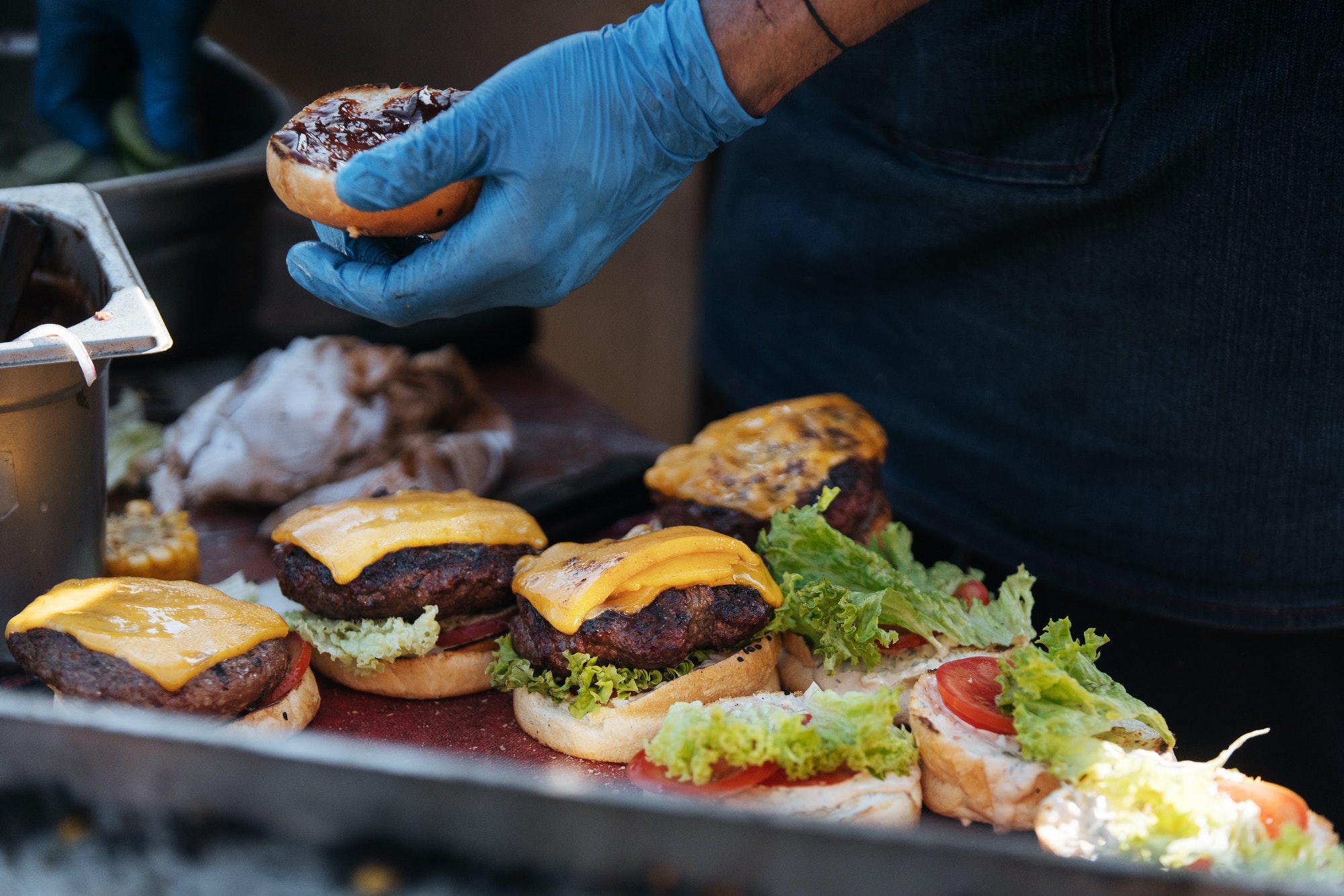 Crop chef making burgers at counter
