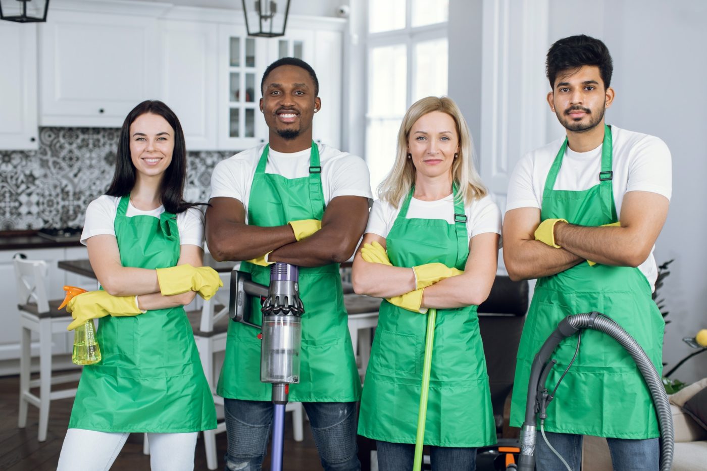 Confident mixed race cleaners standing at apartment