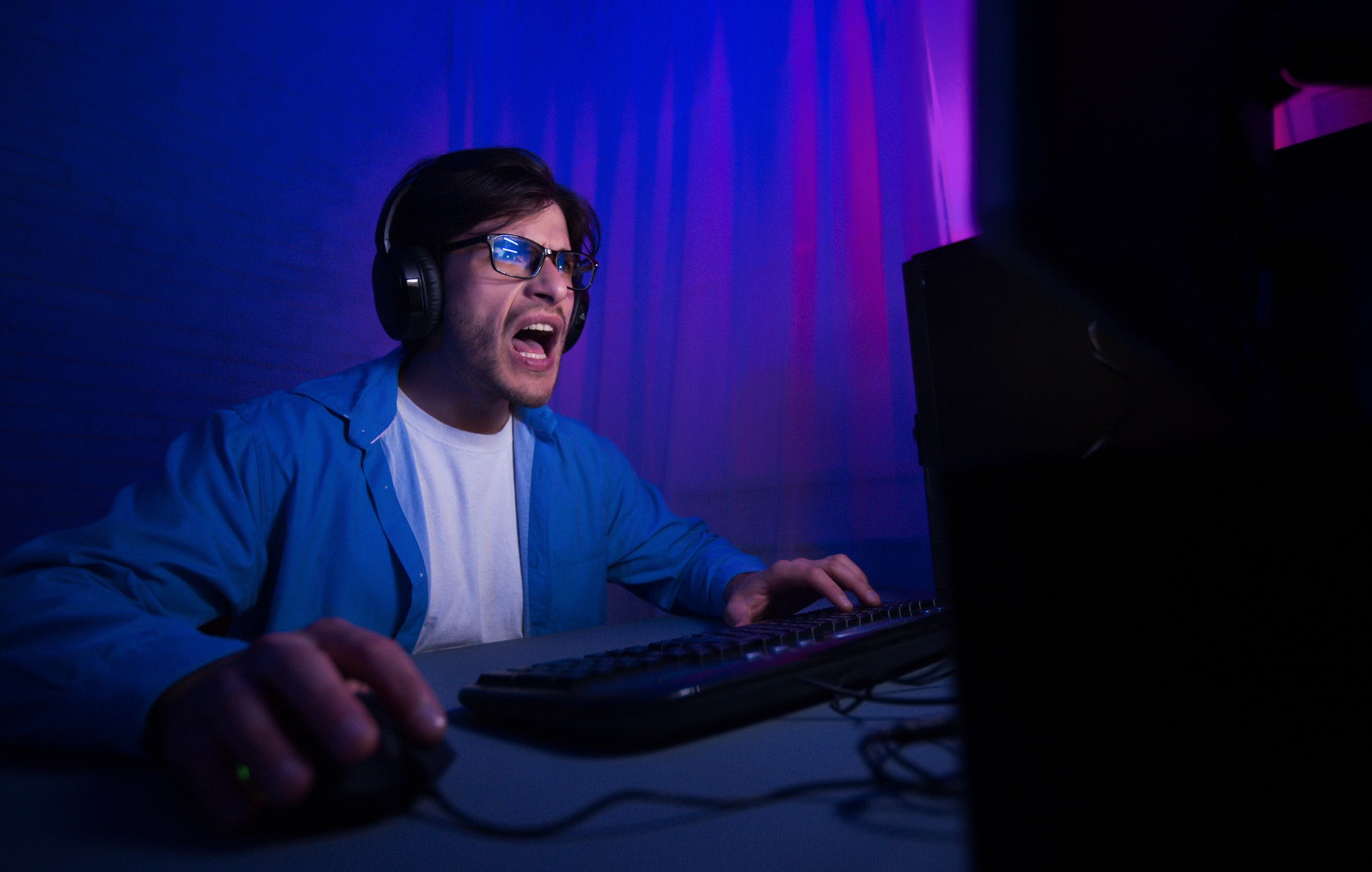 Emotional gamer playing video game online and shouting