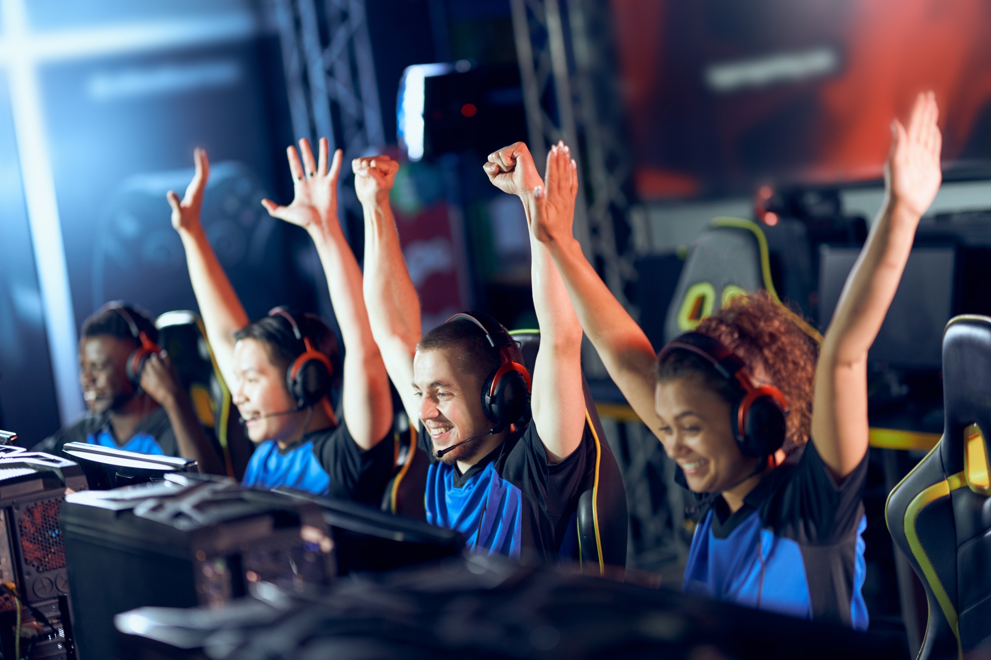 Team of happy professional cyber sport gamers celebrating success while participating in eSports