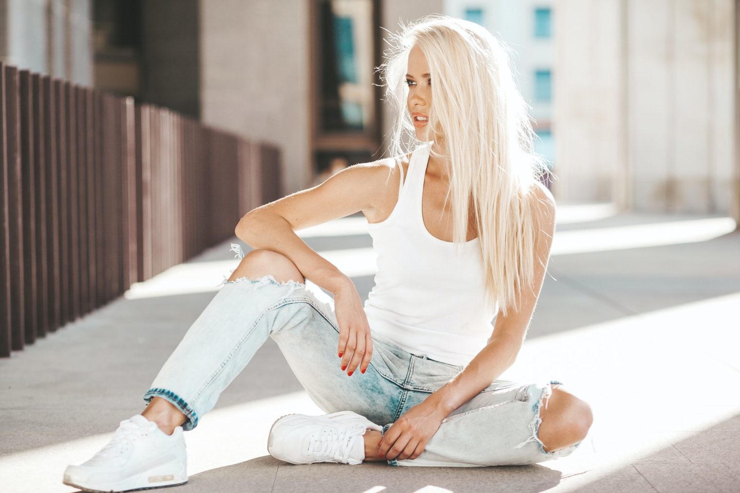 Portrait of young stylish woman in jeans posing outdoors