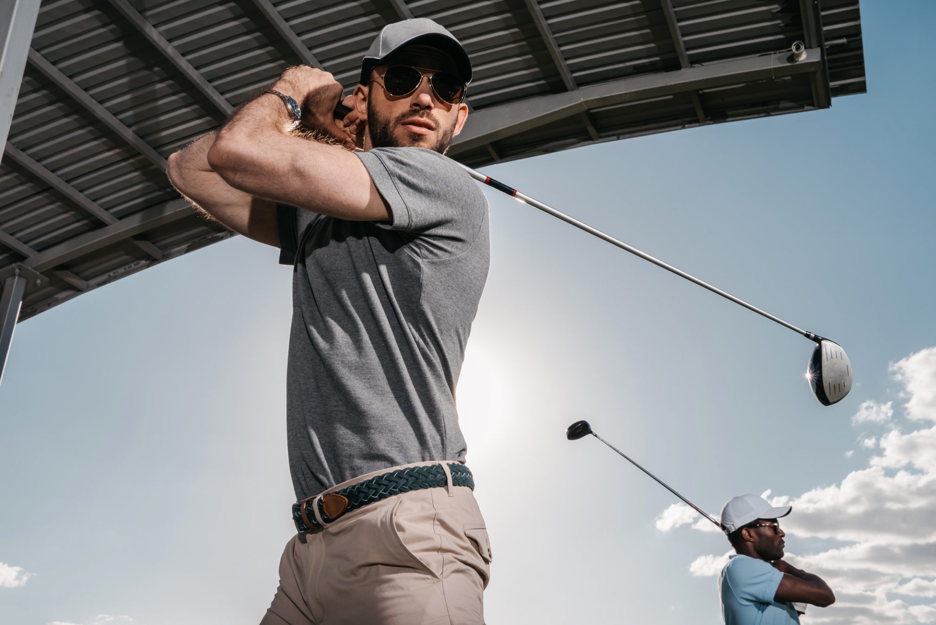 Two young golfers with clubs playing golf together