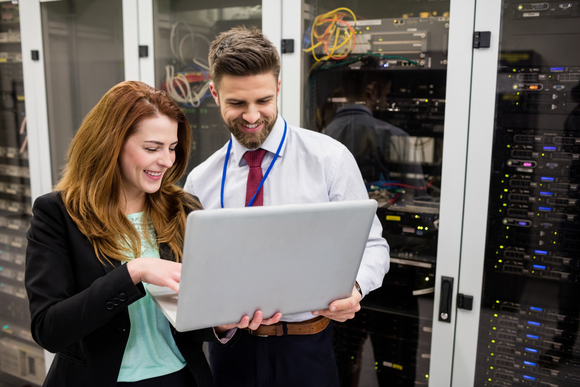 Technicians using laptop while analyzing server