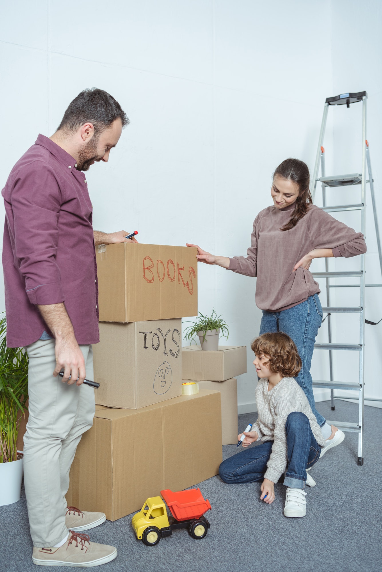 happy family packing boxes while moving in new home