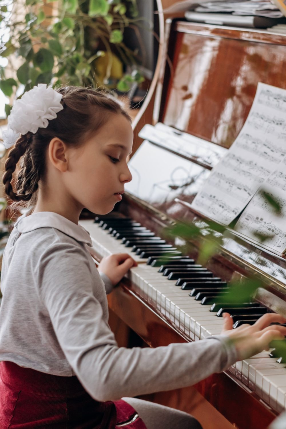 A girl with pigtails plays the piano.