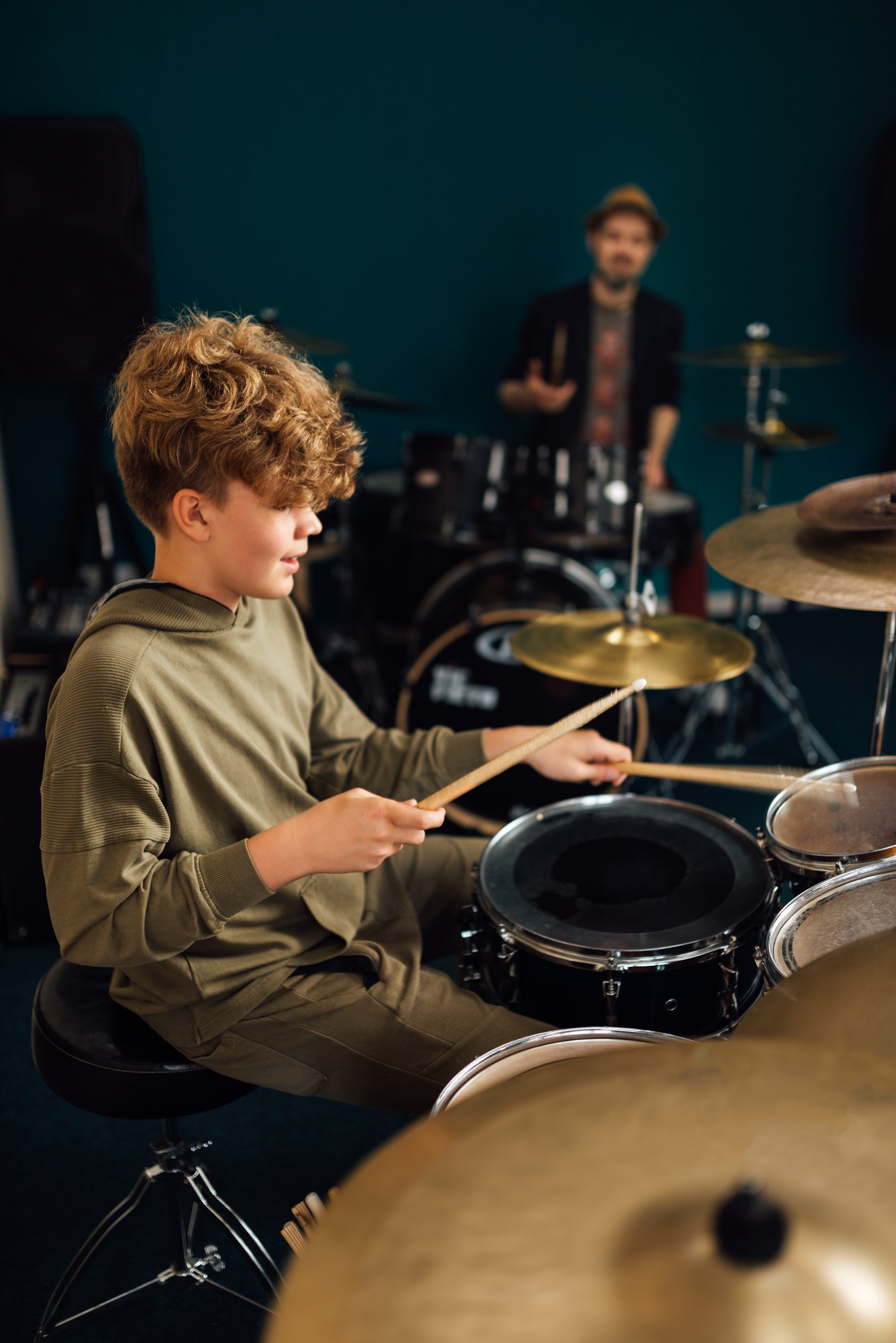 Boy at music school learning to play drums.
