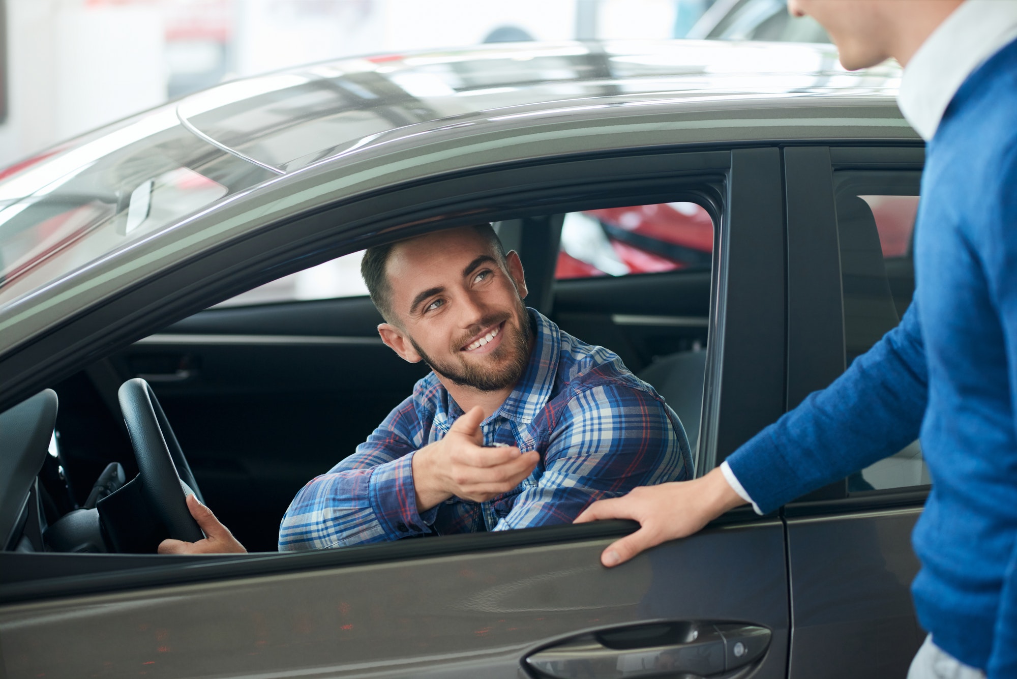 Car seller and customer handshake in car dealership