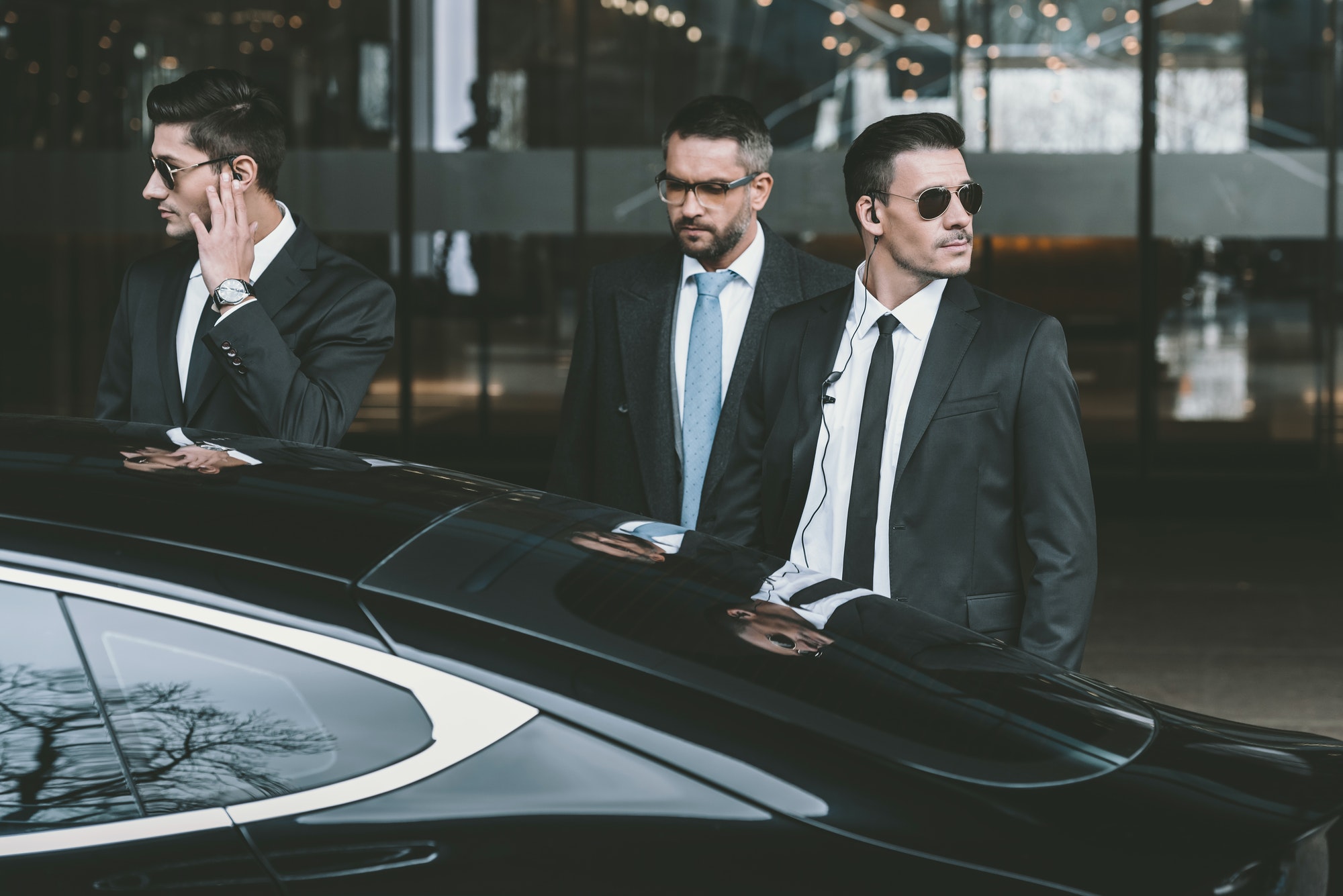 bodyguards going with businessman and reviewing territory near car
