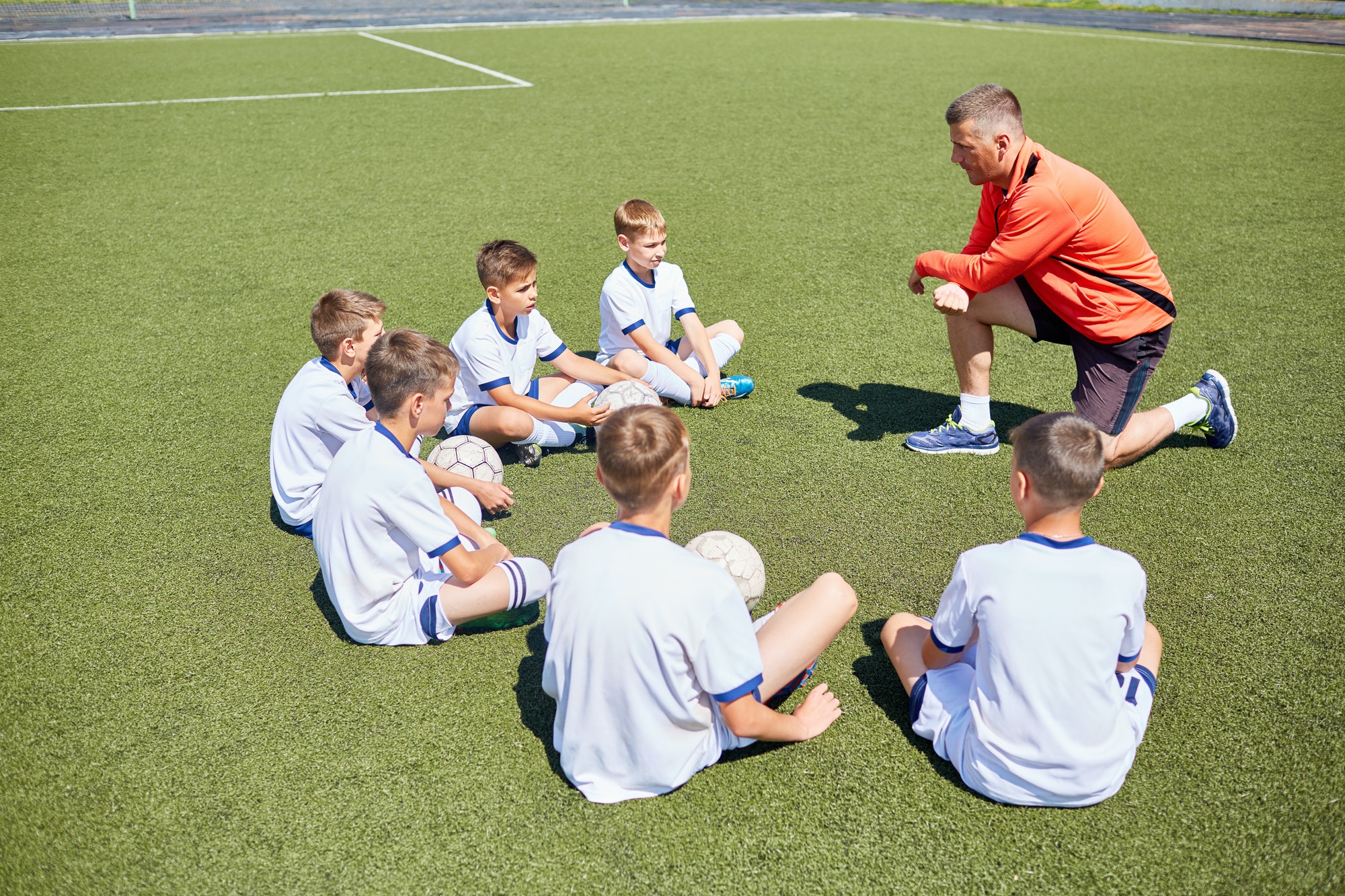 Coach Teaching Junior Football Team