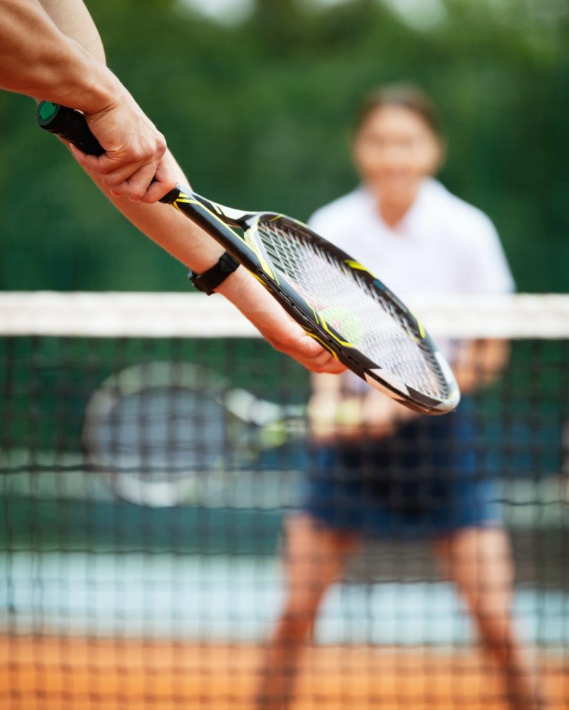 Tennis player prepares to serve ball during tennis match