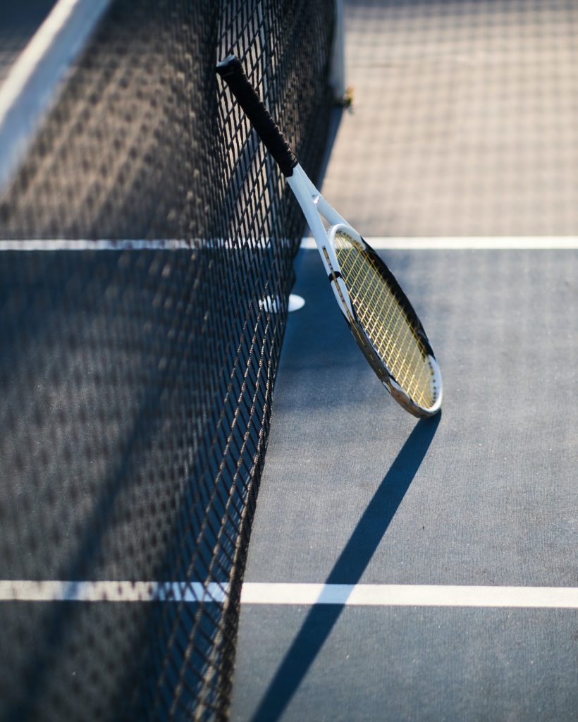 Tennis racquet is standing near tennis net