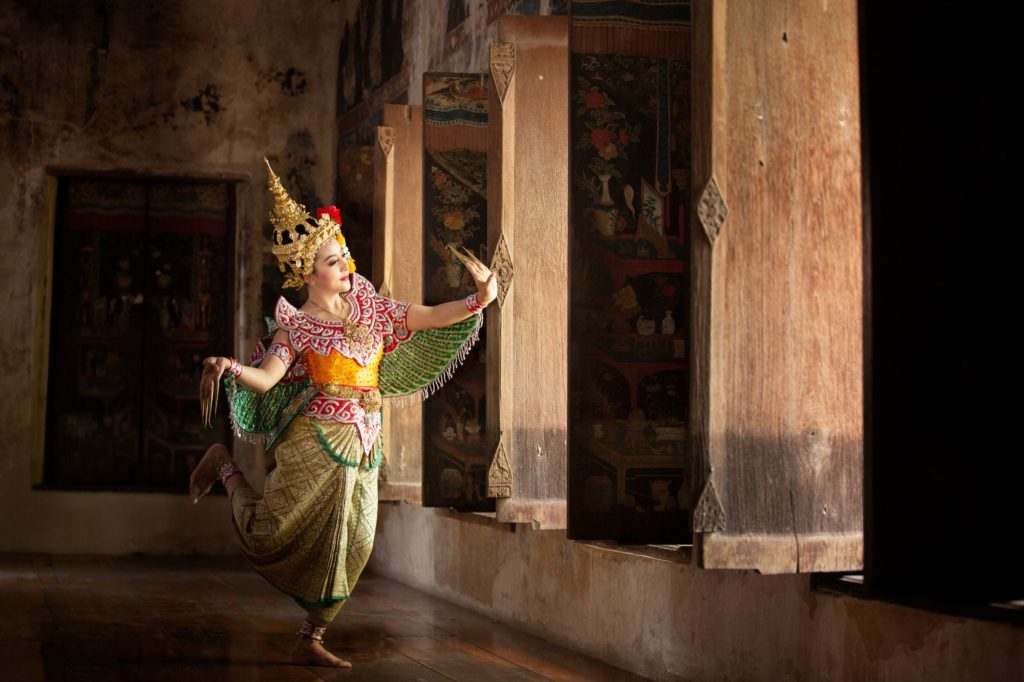 Portrait of Thailand dancer in Kinnaree costume dancing against the temple wall