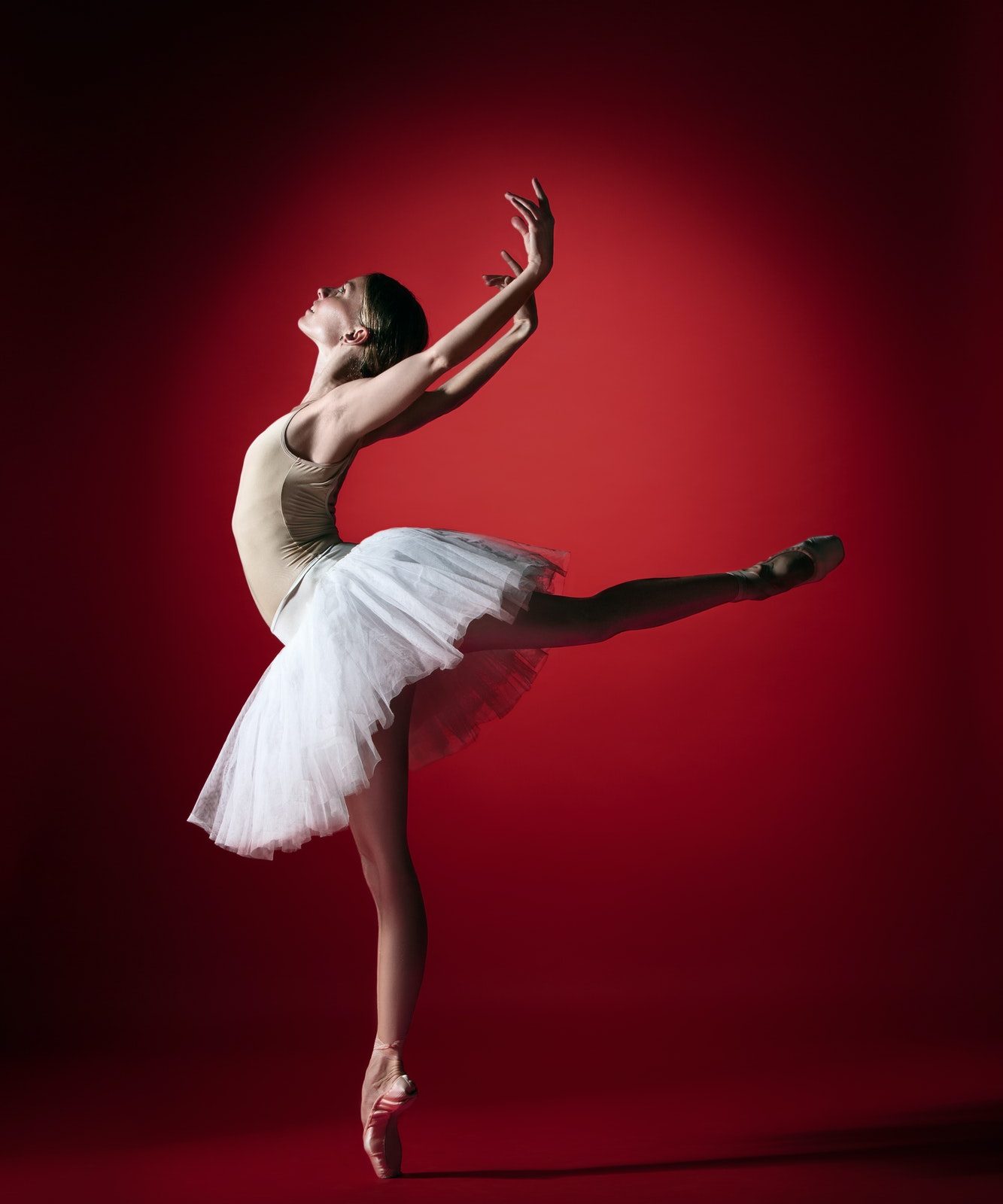 Ballerina. Young graceful female ballet dancer dancing at red studioskill. Beauty of classic ballet.