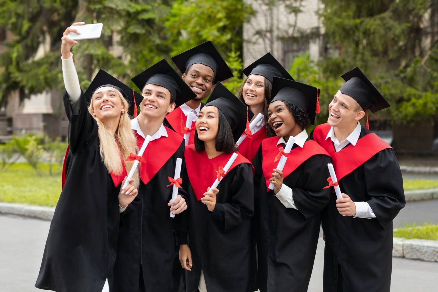 Happy graduates taking selfie together at university campus