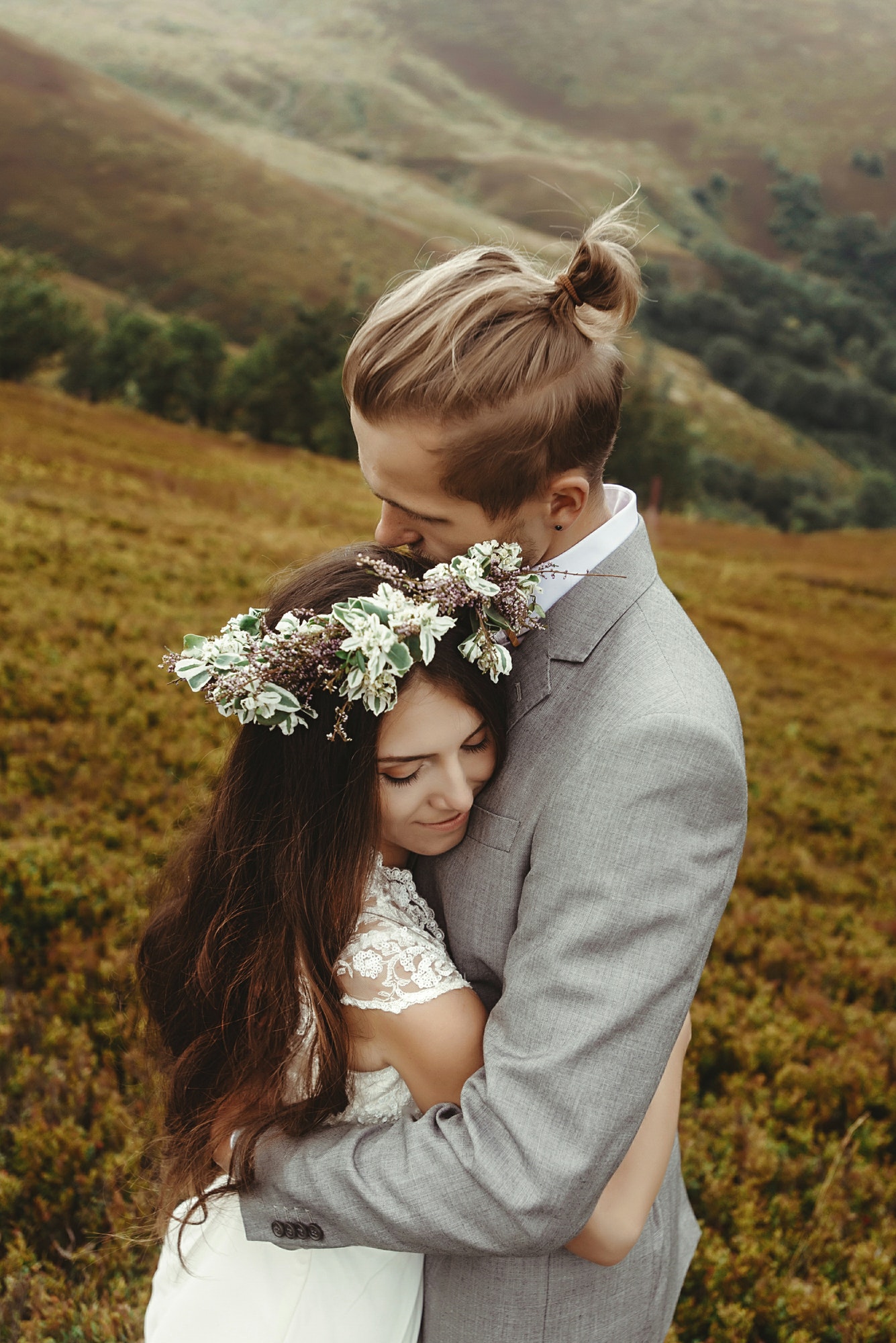 gorgeous bride and stylish groom posing at sunny landscape