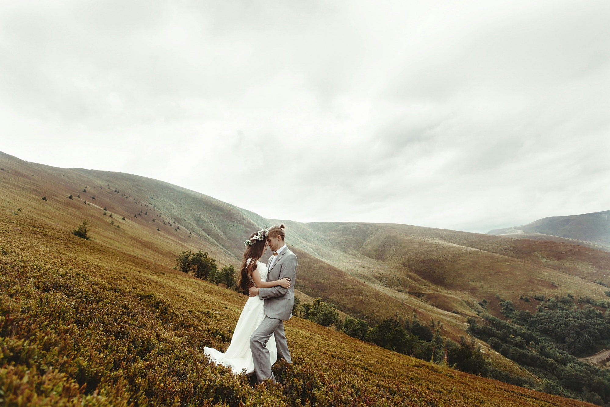 gorgeous bride and stylish groom posing at sunny landscape