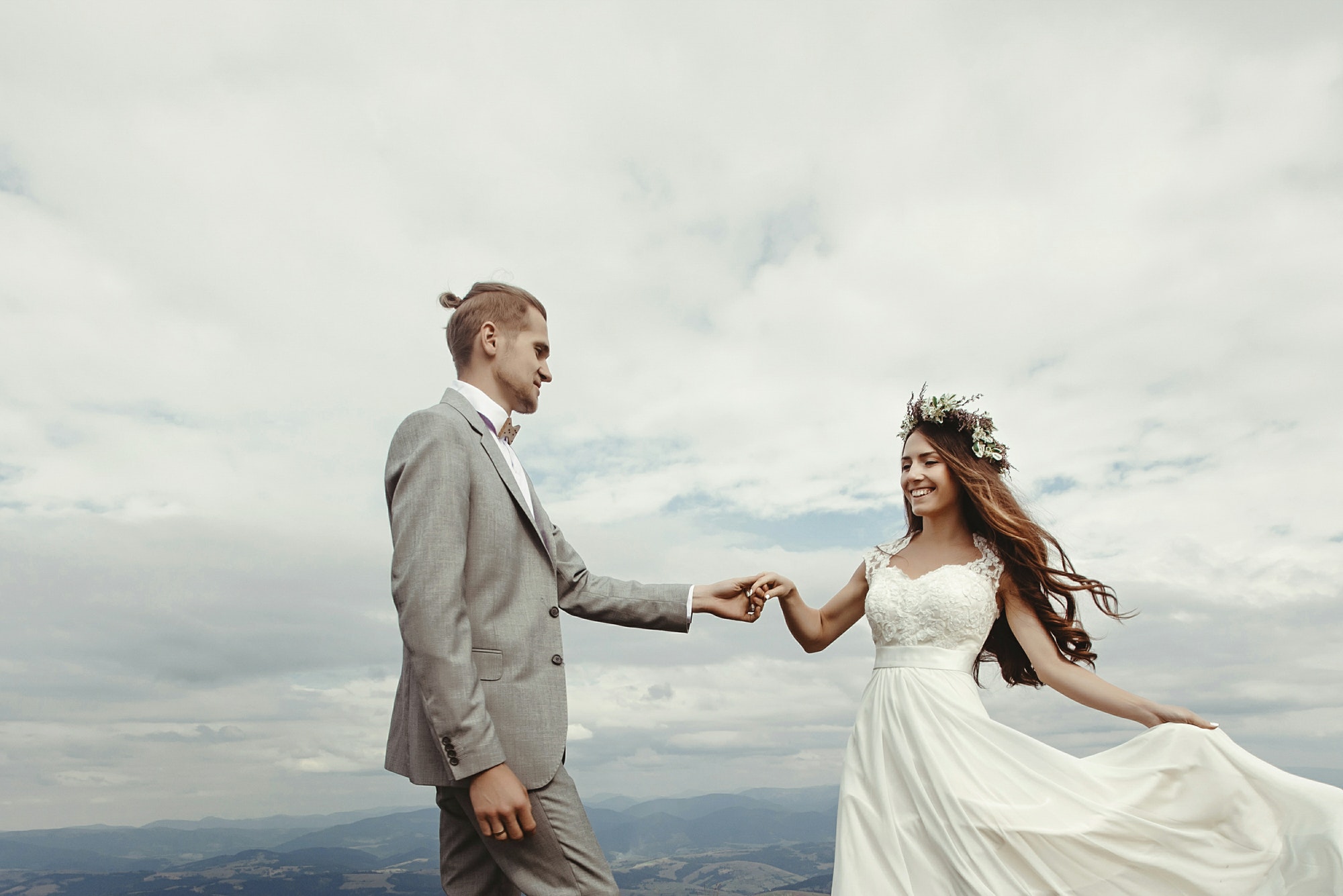 happy gorgeous bride and groom walking at mountains with amazing view