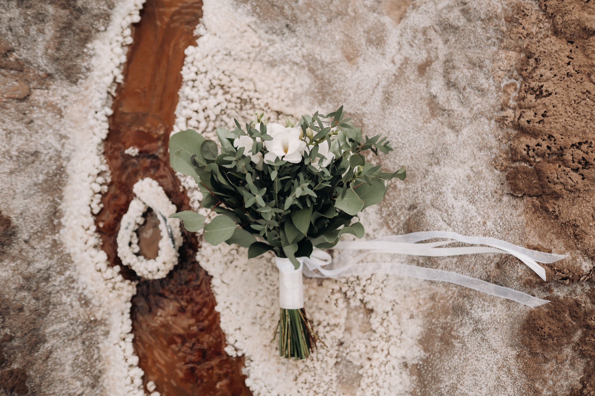 the wedding bouquet rests on a salty texture.The decor at the wedding
