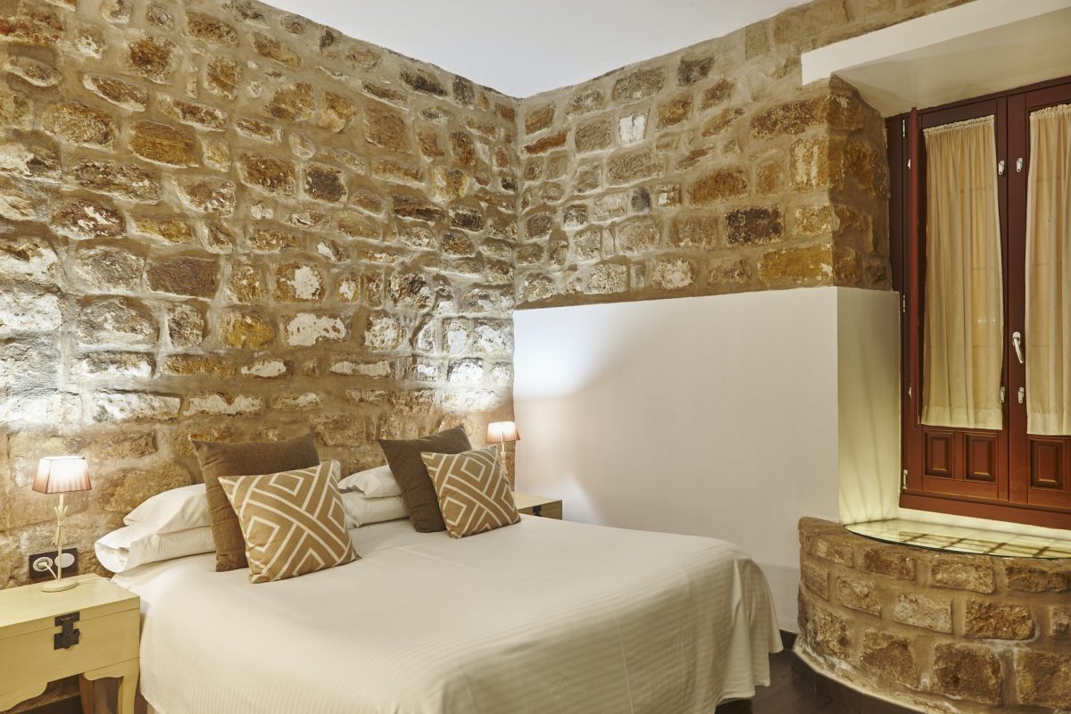 Bedroom with stone walls. Comfortable modern hotel room. Interior architecture
